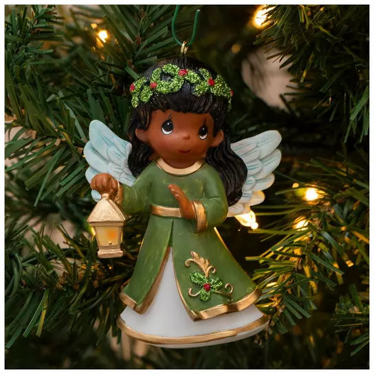 Precious Moments angel ornament with white wings and green dress holding lantern on lit Christmas tree