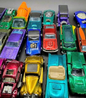Top view of colorful vintage die-cast toy cars and trucks packed closely together