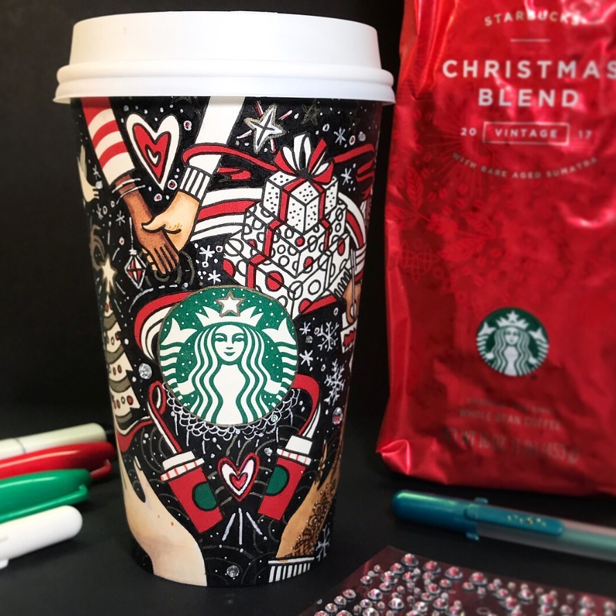 Decorated Starbucks cup with intricate black and white Christmas doodles and the green Starbucks logo