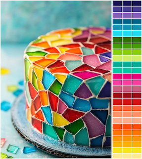 Round cake covered in multicolored mosaic fondant pieces resembling stained glass beside a color palette