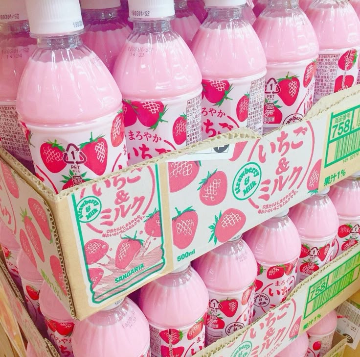 Pink strawberry milk bottles stacked in boxes with Japanese labels and strawberry graphics