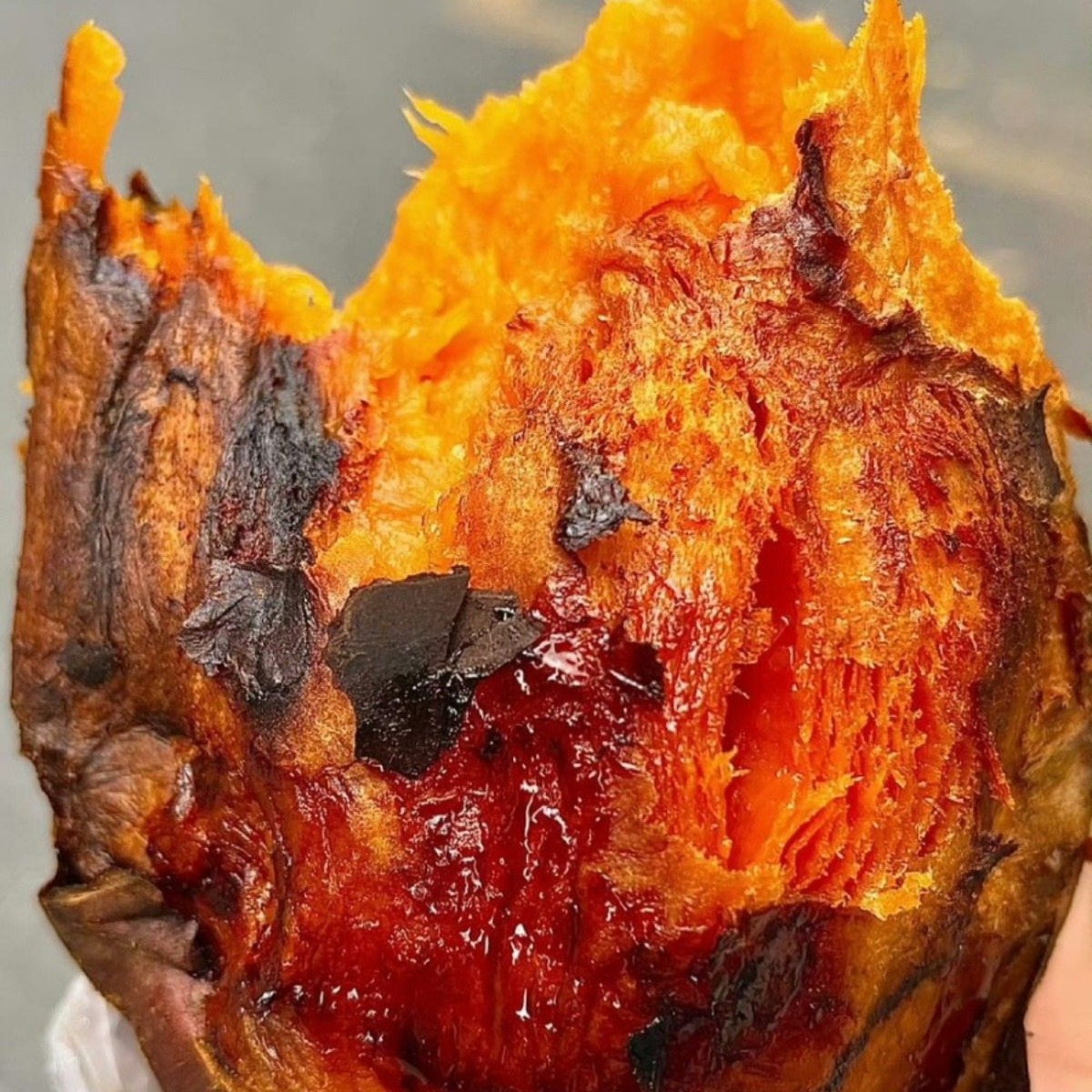 Close-up of a baked sweet potato with orange flesh and charred skin