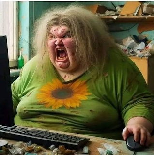 Woman with messy hair shouting at a computer in a cluttered room
