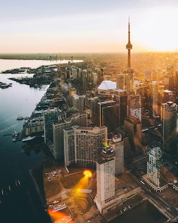 Aerial photo of Toronto skyline with CN Tower and skyscrapers at golden sunset over Lake Ontario