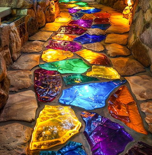 Colorful stained glass panels set in stone floor creating vibrant illuminated pathway