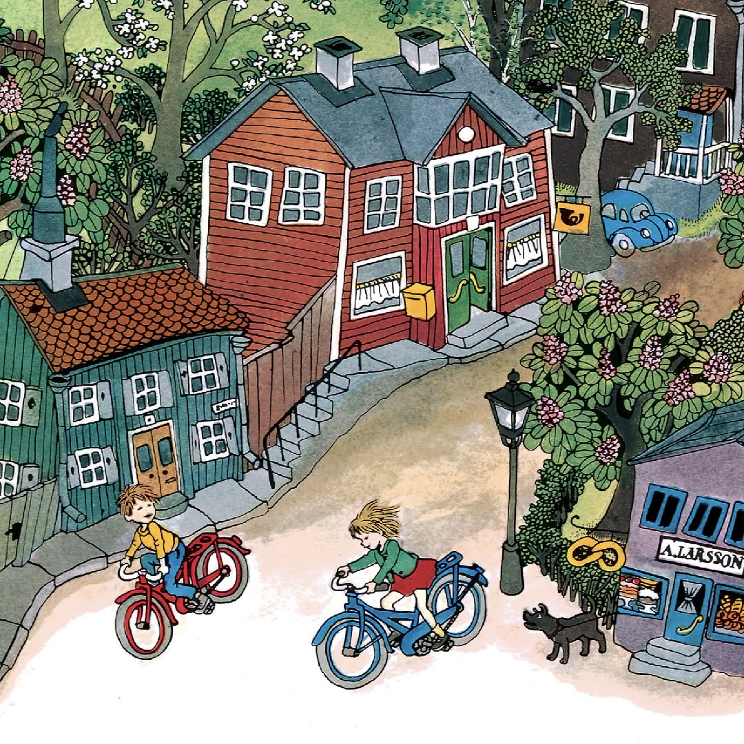 Overhead view of miniature village with red and green houses, toy figures on bicycles, and a lamppost