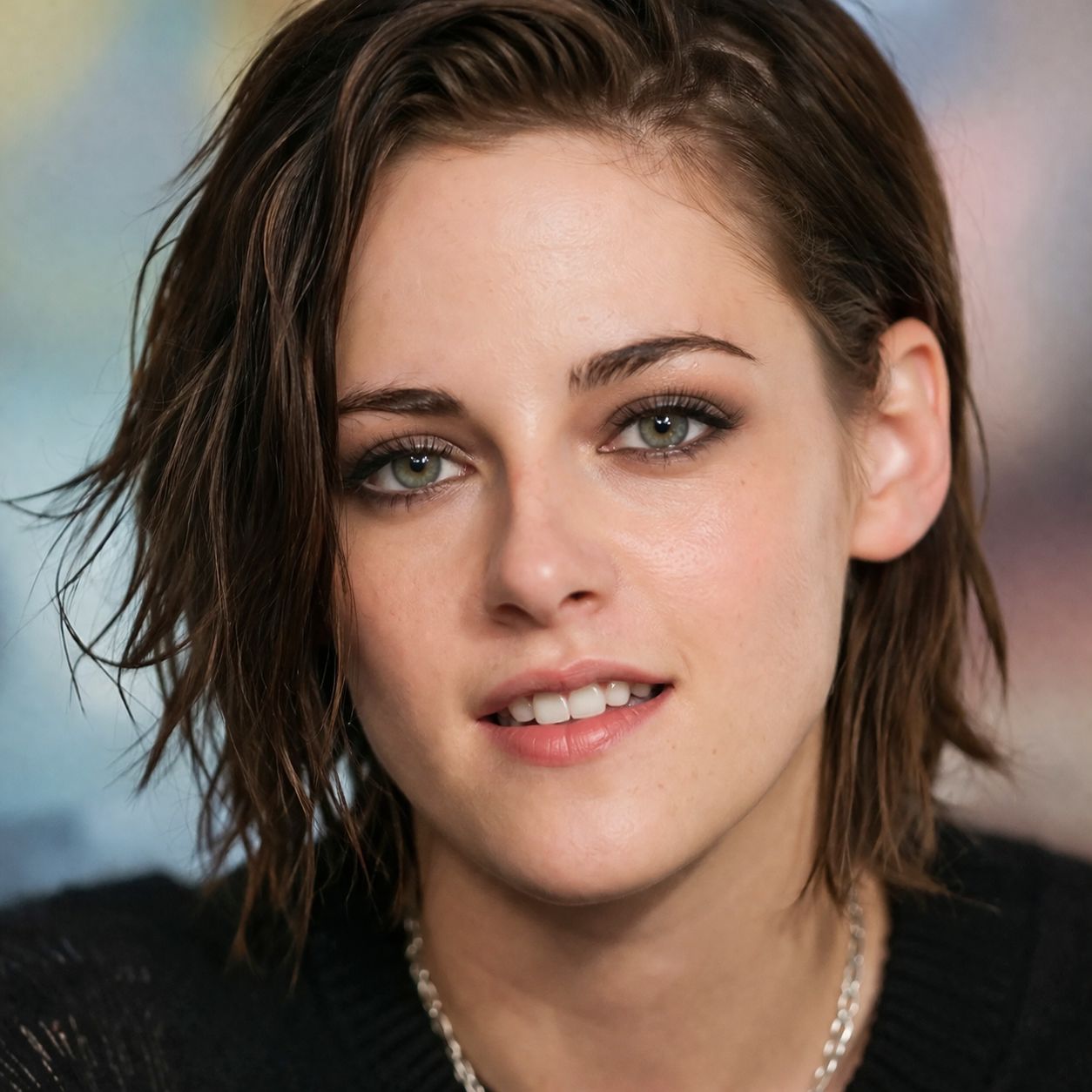 Close-up portrait of Kristen Stewart with short brown hair and a black top