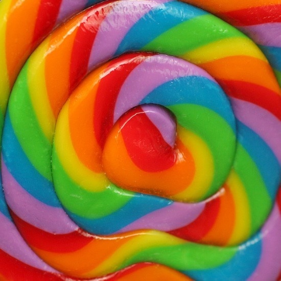 Close-up of a rainbow spiral lollipop with vibrant multicolored swirling stripes