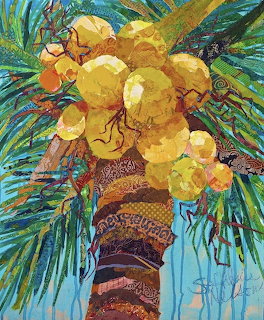 Colorful torn paper collage of yellow coconuts clustered on a textured palm trunk with green and blue fronds