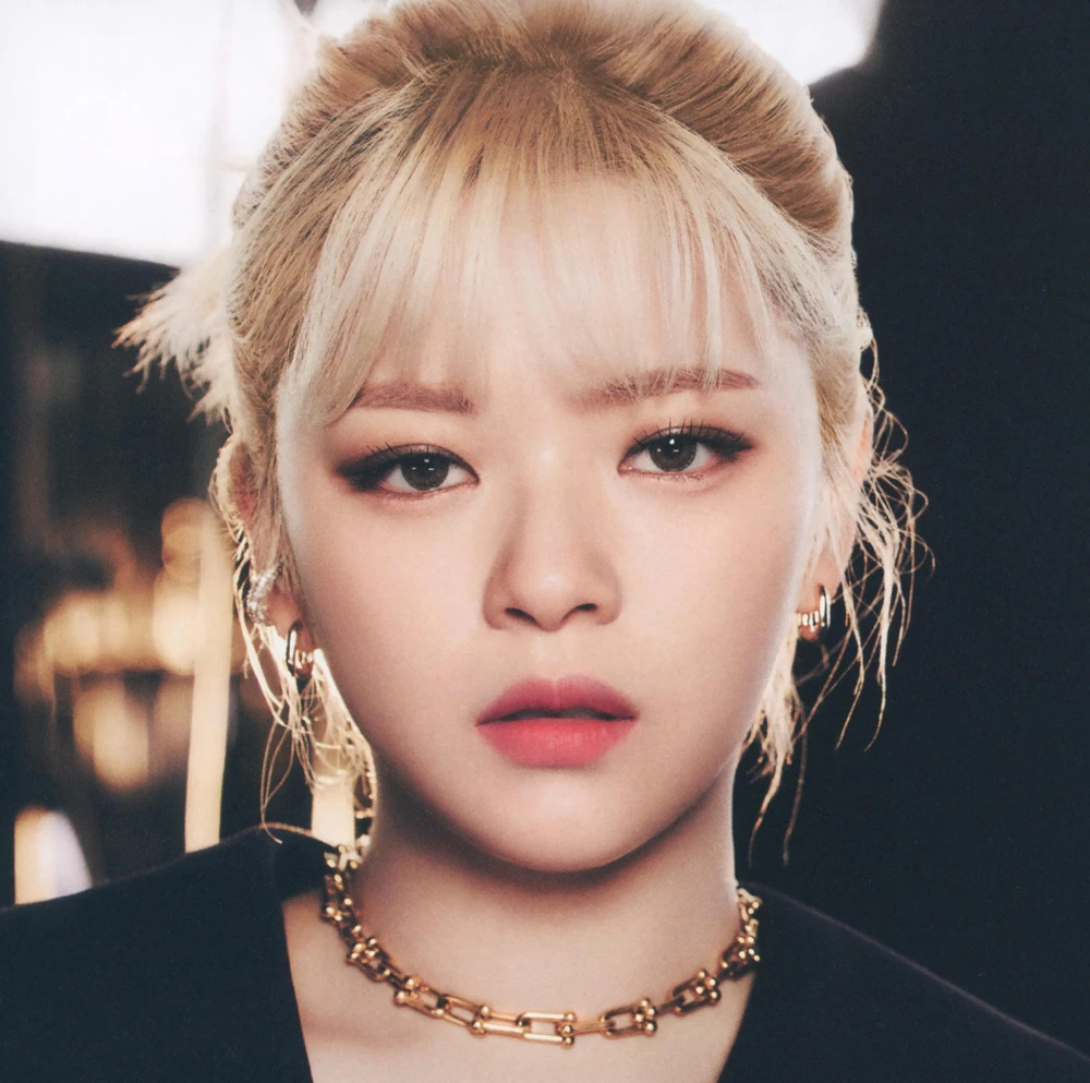 Close-up portrait of Jeongyeon with blonde hair, earrings, and a gold chain necklace