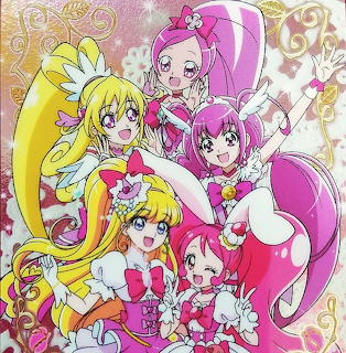 Anime magical girl group of five characters in pink and yellow costumes with sparkles