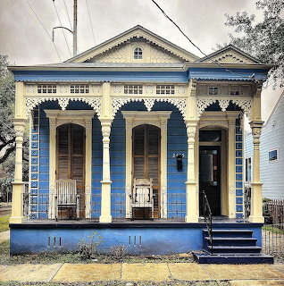 Victorian double house with blue facade, cream trim, ornate columns and arched doorways