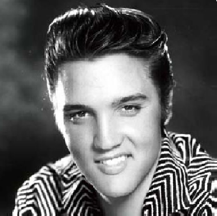 Black and white portrait photo of Elvis Presley smiling in a patterned shirt
