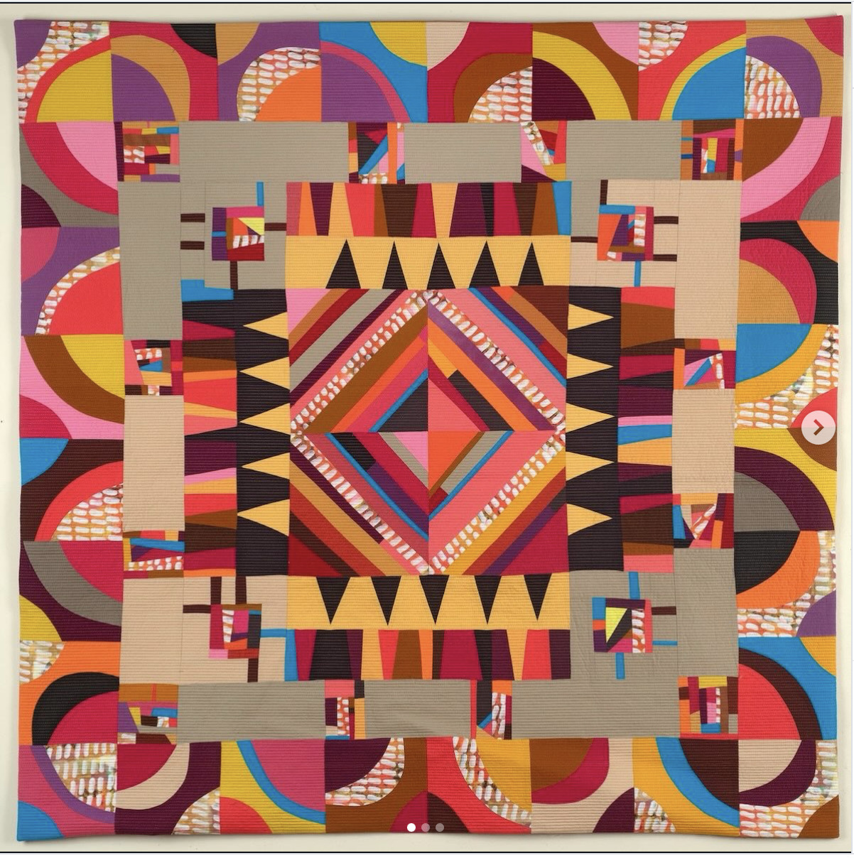 Colorful geometric quilt with a central diamond medallion and patterned patchwork border