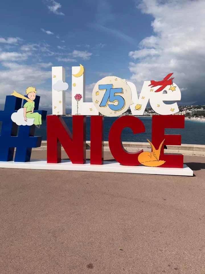 Colorful I Love Nice sign with Little Prince characters on the Nice promenade under a blue sky