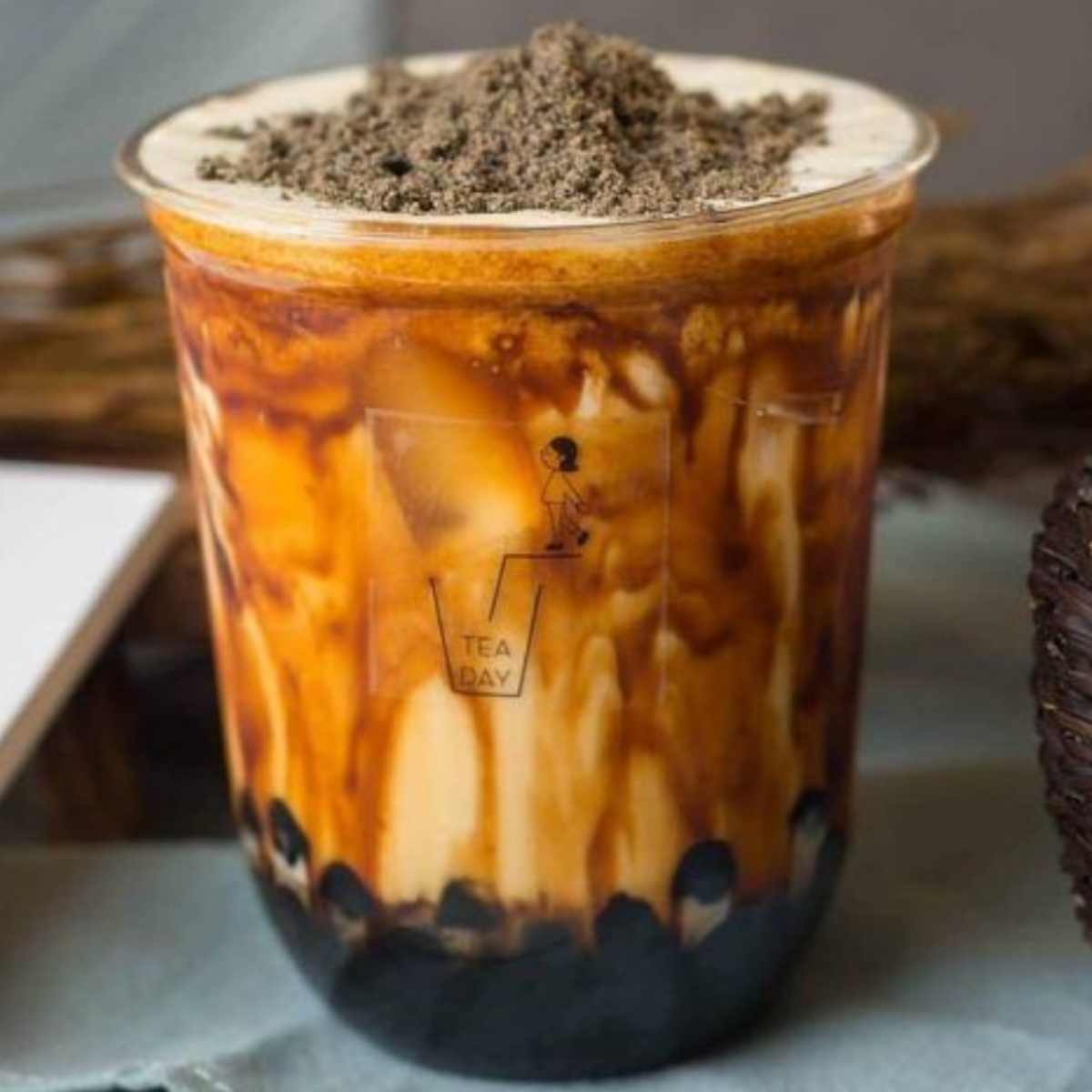 Plastic cup of brown sugar boba milk tea with black tapioca pearls