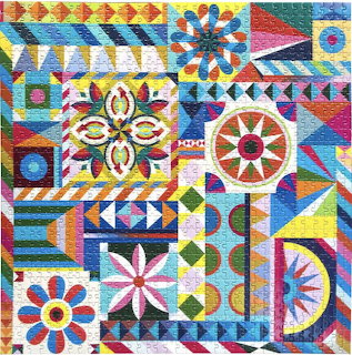 Colorful patchwork quilt with geometric blocks, flowers, and traditional quilt patterns in red, blue, yellow, and green