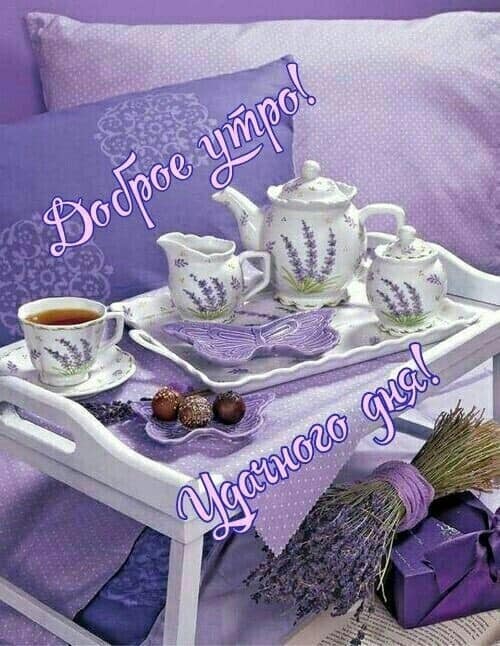 White tea set with lavender decoration on purple tray over bed with purple linens