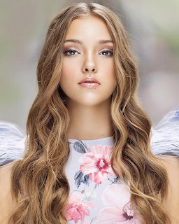 Portrait of a young woman with long wavy hair in a pink floral top