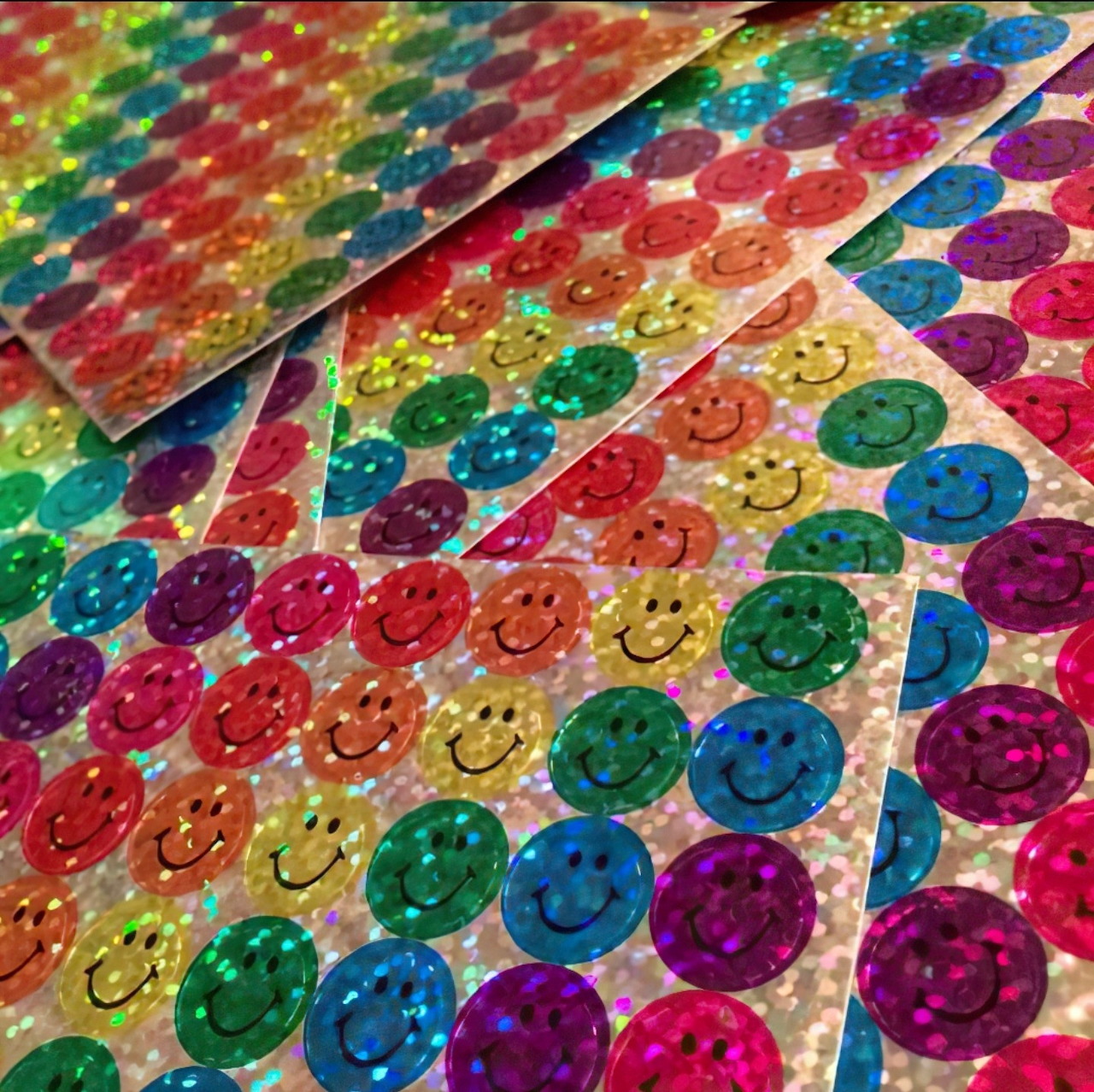 Holographic sticker sheets with rainbow smileys and geometric patterns in bright colors