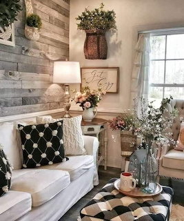 Cozy farmhouse living room with white couch, patterned ottoman, wood plank wall and rustic decor