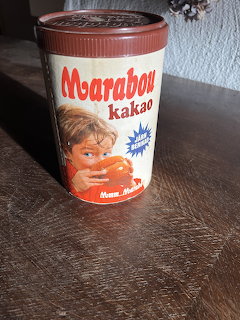 Vintage Marabou kakao tin with brown lid and retro label featuring a child, on a wooden table