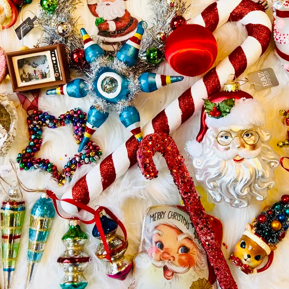 Festive Christmas ornaments including Santa faces, candy canes, blue baubles, and glittery decorations on white background