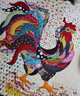 Handmade quilt with multicolored patchwork rooster appliqué on white polka dot fabric background