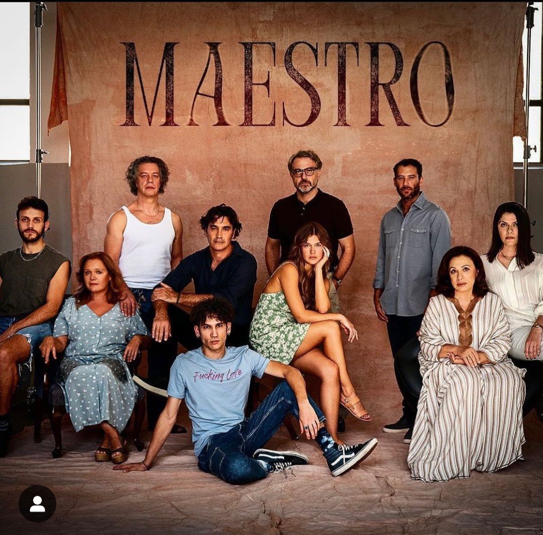 Nine people posing indoors beneath a backdrop reading MAESTRO