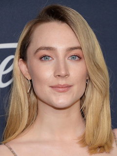 Close-up portrait of a young blonde woman with blue eyes and hoop earrings