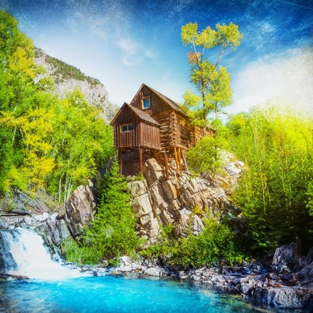Rustic wooden cabin on rocky cliffs above a turquoise river with trees and a small waterfall