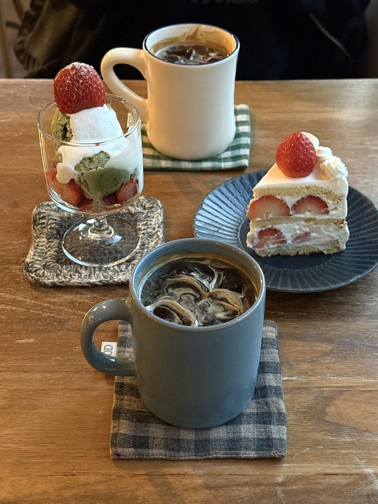 Top-down café table with iced coffee, hot coffee, strawberry shortcake, and a fruit parfait