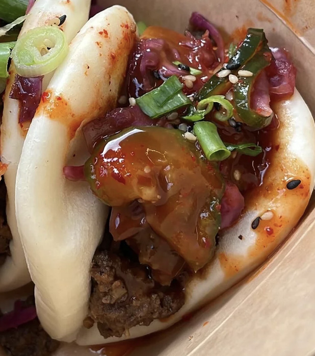 Close-up of bao buns with minced meat, vegetables, and sesame seeds