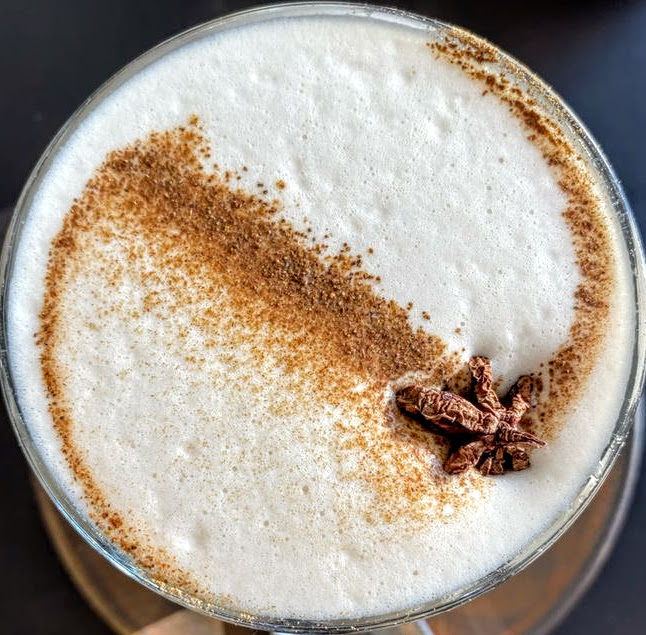 Overhead view of chai latte with cinnamon swirl and star anise on foam