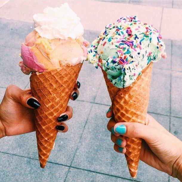 Two people holding ice cream cones with white and green scoops topped with sprinkles