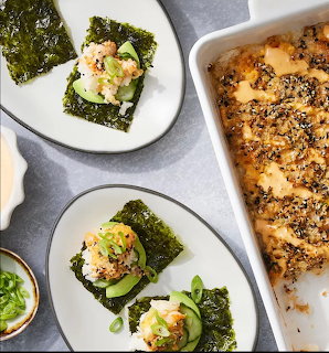 Sushi bake casserole with individual portions assembled on nori seaweed sheets with cucumber and avocado