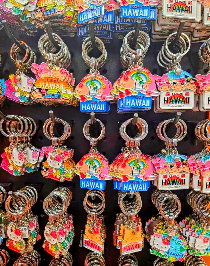 Assorted Hello Kitty keychains with Hawaiian tropical themes on display