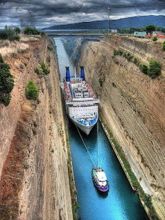 Large ship and small boat passing through the narrow Corinth Canal in Greece