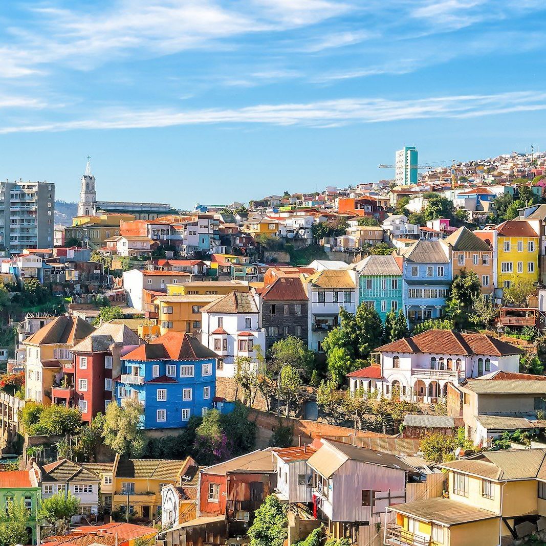 Vibrant multicolored houses covering hillsides in Valparaíso, Chile with blue sky