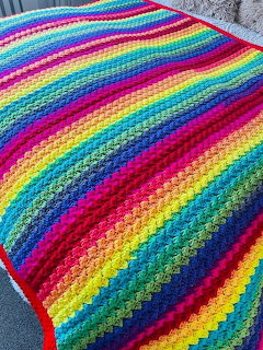 Rainbow striped crochet blanket with colorful granny square pattern