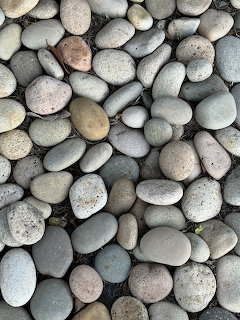 Close-up of smooth rounded river pebbles in gray, beige, and pink tones