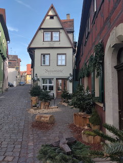 Traditional half-timbered house on cobblestone street in historic German town with outdoor seating