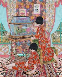 Two women in red floral kimonos looking at an ornate cabinet in a colorful patterned interior