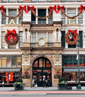 Macy's storefront facade decorated with wreaths, red bows, and Christmas garlands