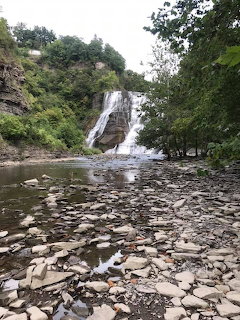 Ithaca Falls waterfall dropping into a rocky pool with trees and cliffs in the background