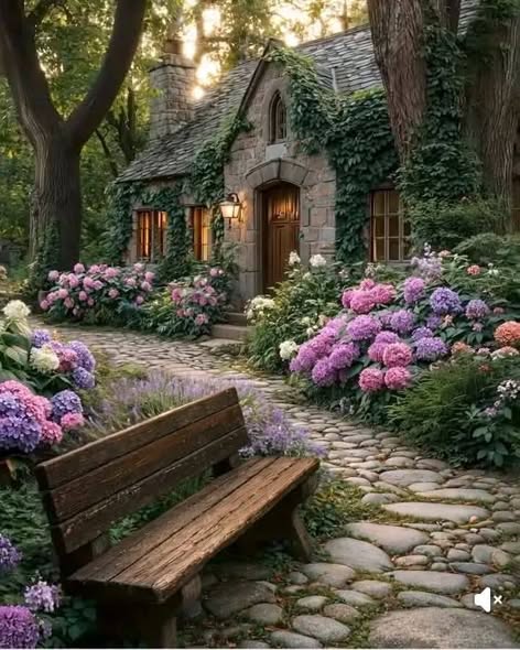 Stone cottage with hydrangeas, cobblestone path, and wooden bench in a garden