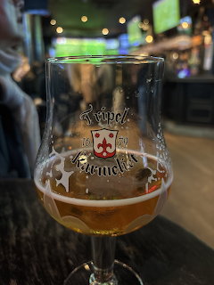 Partially filled beer glass on a table in a dimly lit bar