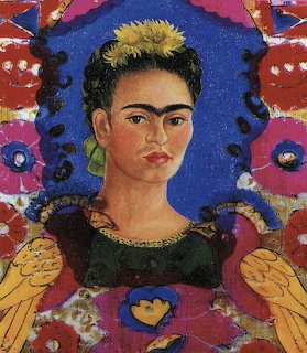 Frida Kahlo self-portrait painting with blue background, flowers, and yellow birds in ornate frame