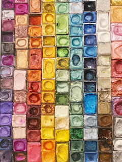 Grid of watercolor paint pans in many vibrant colors arranged in rows