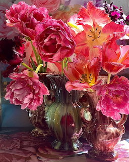 Pink and coral flowers arranged in an ornate glass vase